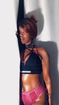 a woman in lingerie posing in front of a curtain